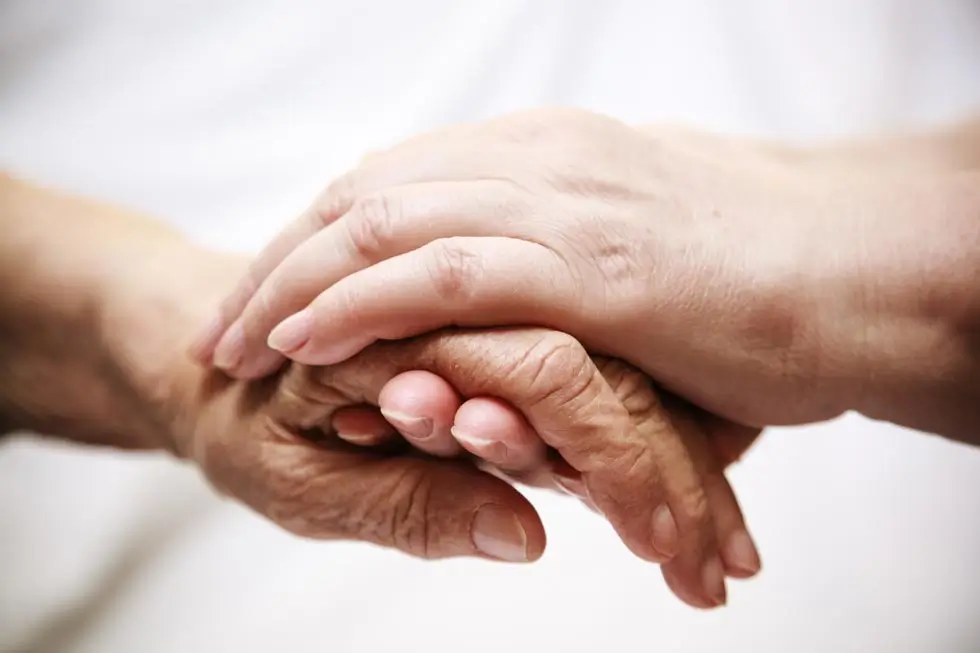 Eine Hand hält behutsam eine andere Hand
